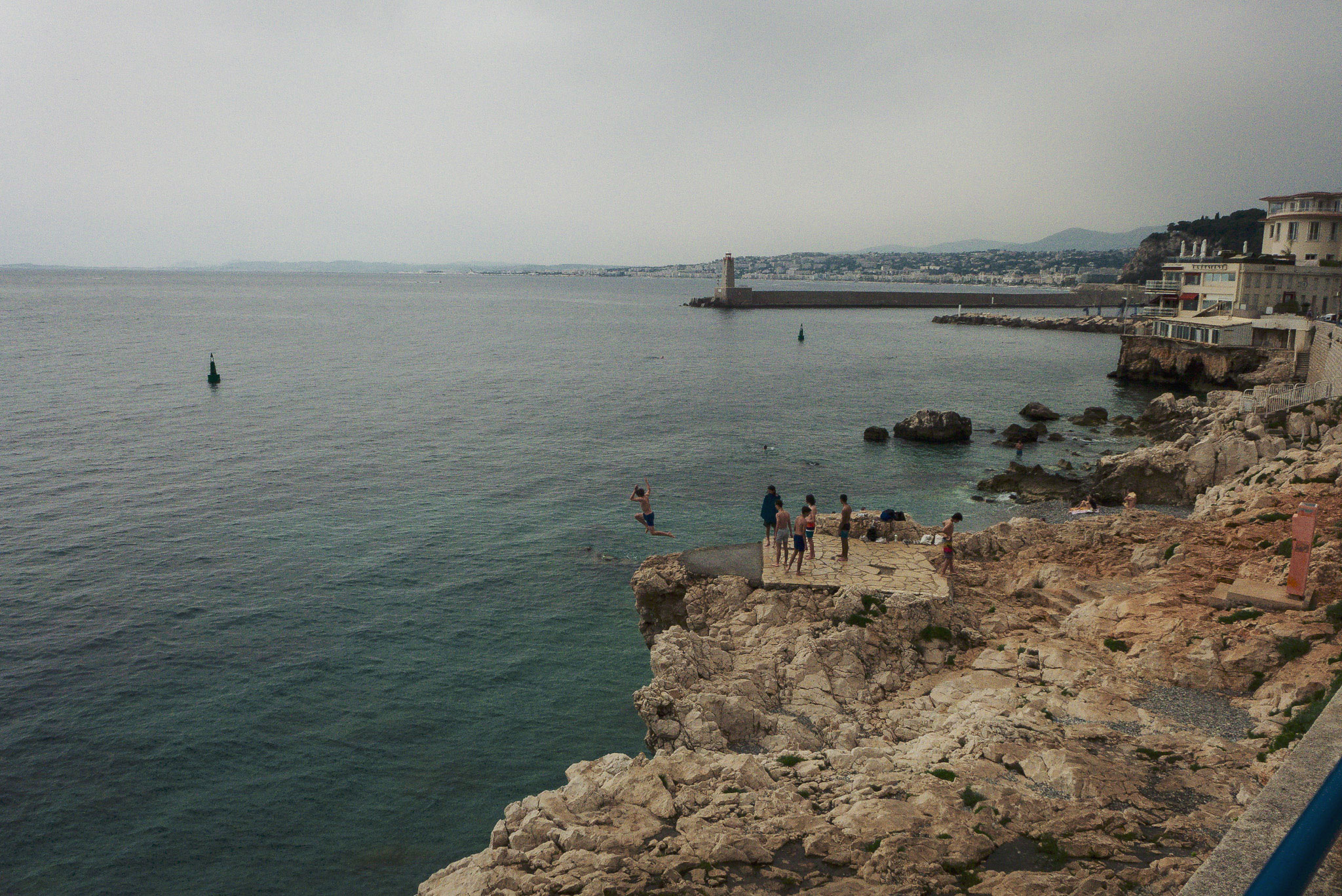 A young boy jumping from the rocks into the sea at La Réserve de Nice